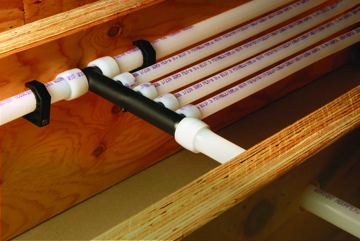 PEX multiport tee mounted across floor joists, from our Lake Forest guide: Electric Tankless Water Heater Installation